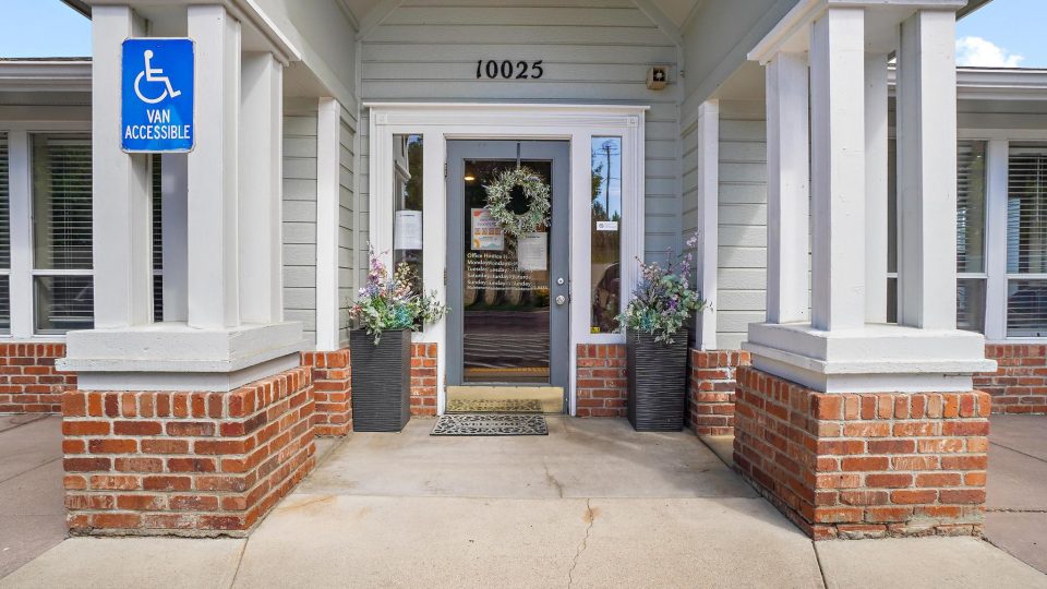 the entrance to a building with a door and a sign at The Residences at Bear Creek