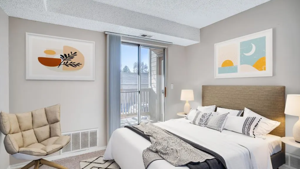 a bedroom with a bed, chair and a television at The Residences at Bear Creek