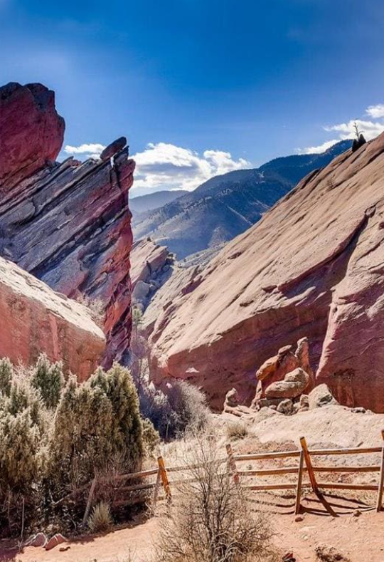 a fence and rocks in front of a mountain at The Residences at Bear Creek