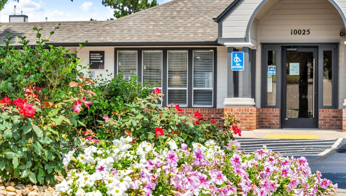 a building with flowers and bushes in front of it at The Residences at Bear Creek