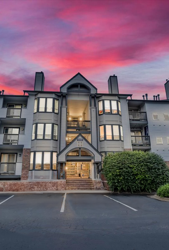 the sunset over an apartment complex in the mountains at The Residences at Bear Creek